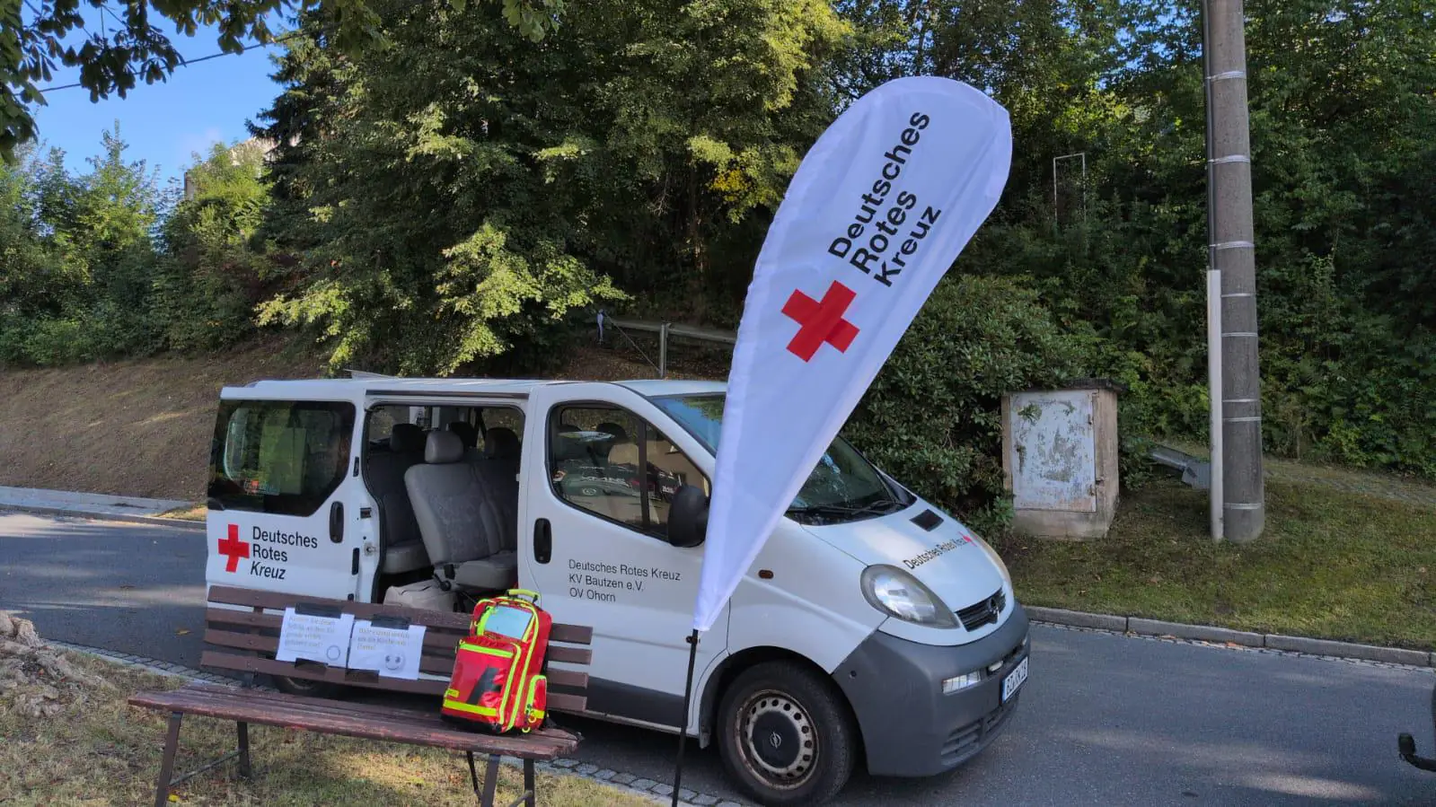 Fahrzeug und Infostand des DRK Ortsverein Ohorn mit Deutsches-Rotes-Kreuz-Flagge